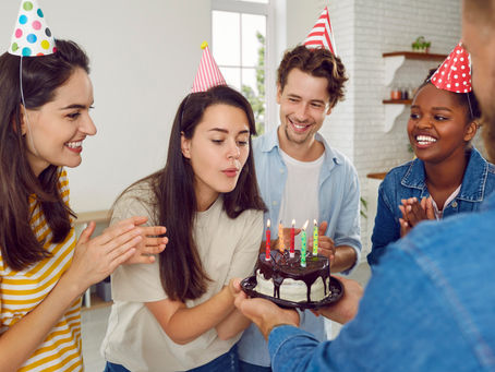Personne soufflant des bougie sur un gâteau au chocolat