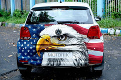 Car with eagle and American flag custom wrap designs displaying Motorik license plate