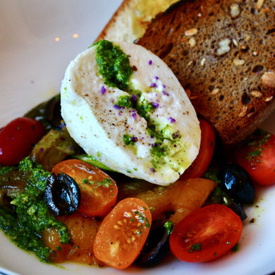 Grilled antipasti vegetables with wild garlic pesto, creamy burrata, cherry tomatoes, and toasted bread – a light vegetarian starter with Mediterranean flair.