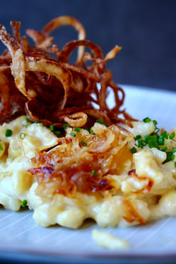 Cremige Käsespätzle mit Röstzwiebeln und Feldsalat. Ein vegetarischer Klassiker im Hüttenstil neu interpretiert