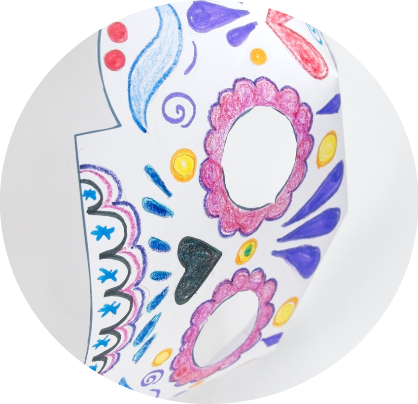 Colorful, hand-drawn Day of the Dead mask with floral and geometric patterns in purple, pink, and yellow on a white background.