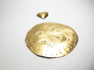 An image of a sun made out of tin foil embossing. 