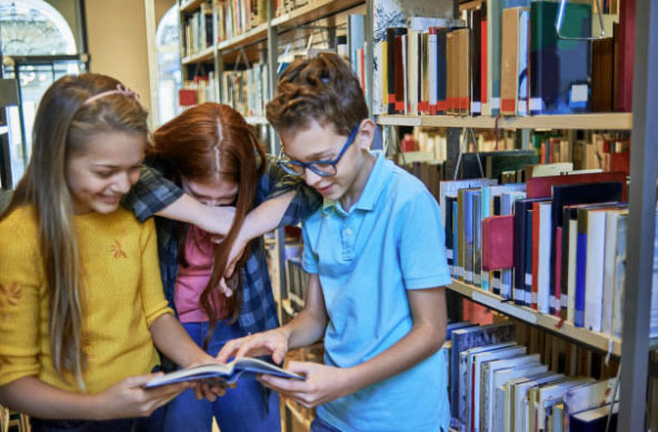 Kids reading a book in the library