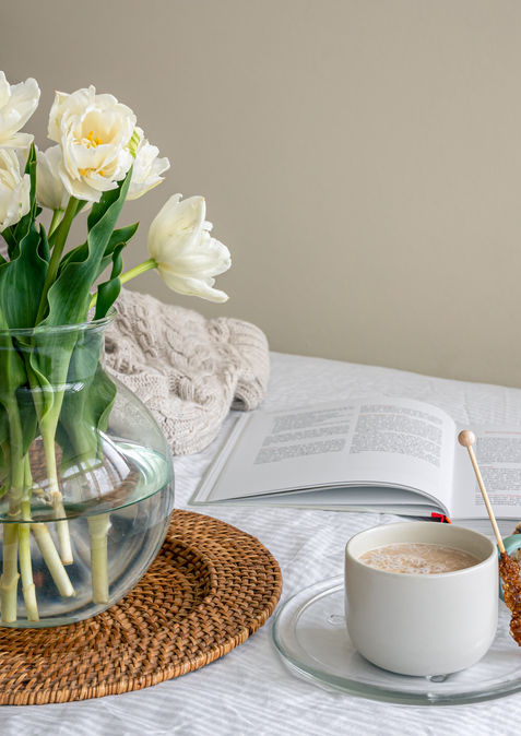 cozy-composition-with-a-bouquet-of-flowers-coffee-and-a-bun-in-bed.jpg