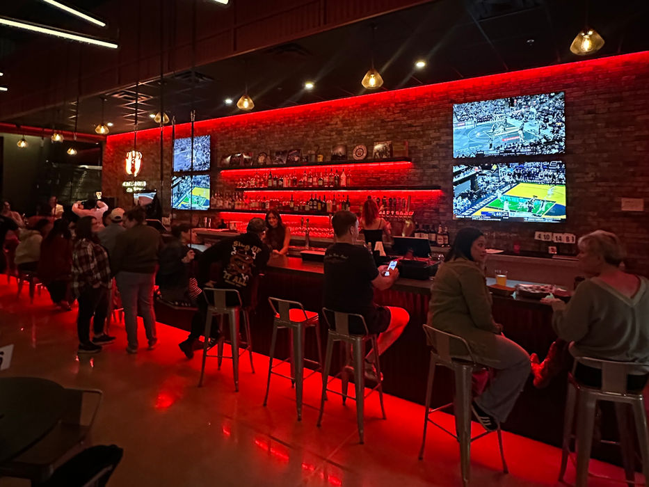 Red-lit interior of CultureClub bar with patrons enjoying the night