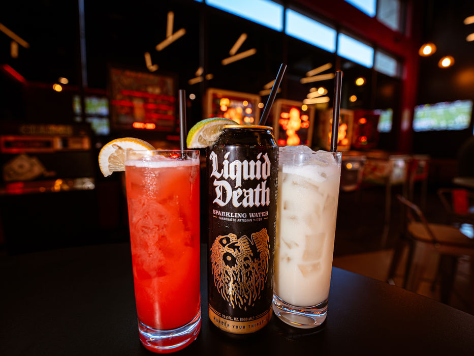 Signature cocktails and a Lone Star beer on the bar counter at CultureClub Austin