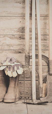 boots, gloves, and tools in a wooden shed