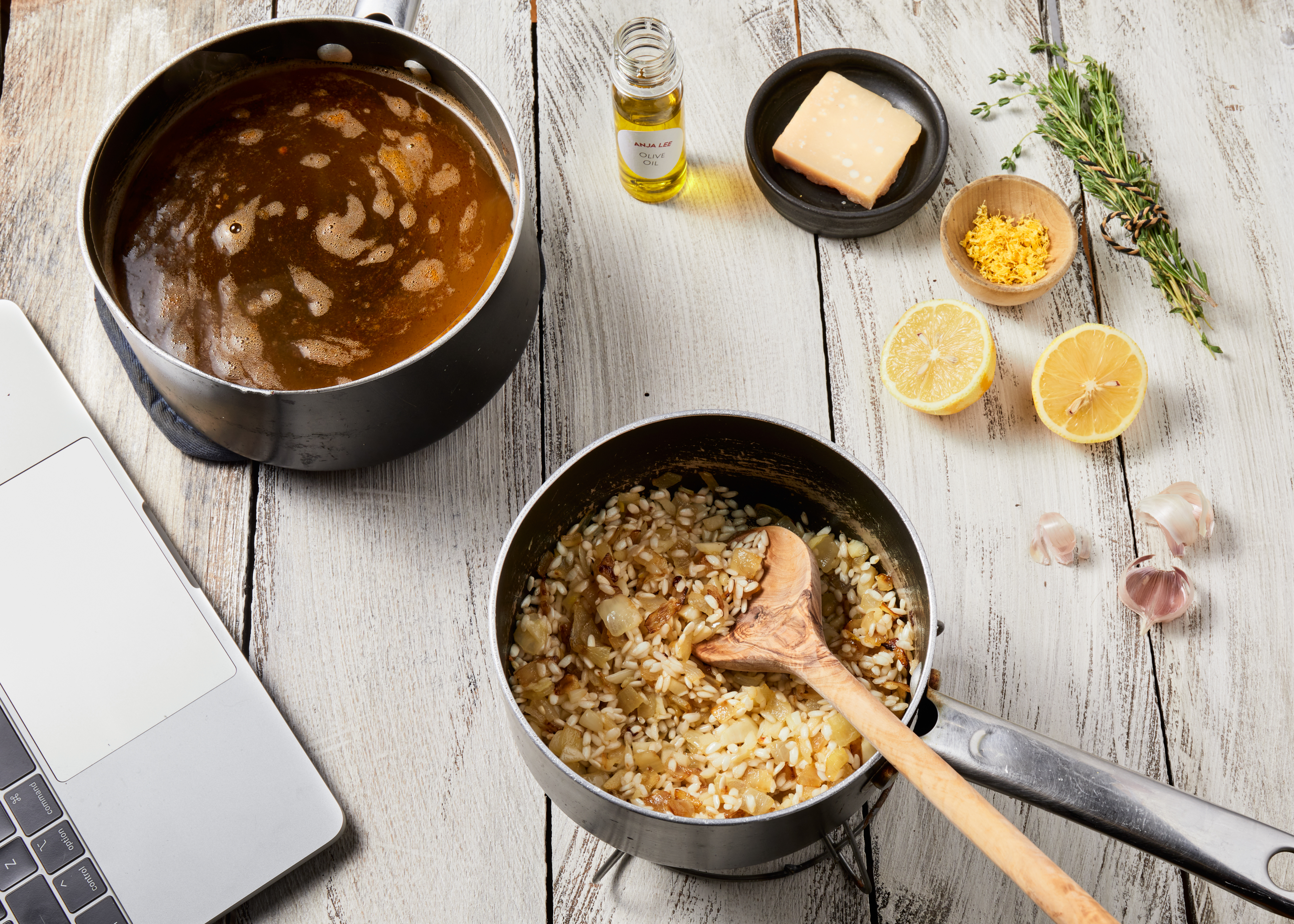 Risotto and soup cooking on the stove beside a laptop during a virtual class