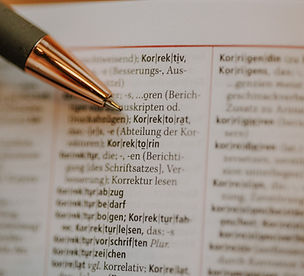 Nahaufnahme des Wortes Korrektorat im Wörterbuch und eine Kugelschreiberspitze.