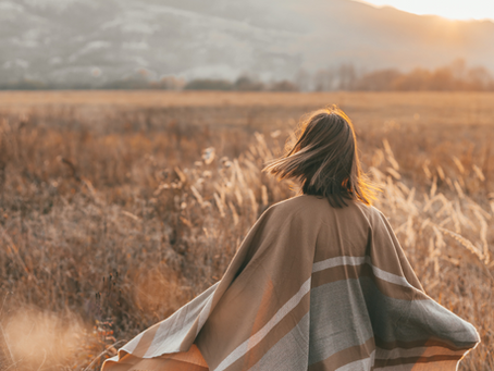 Person sitting quietly in a natural setting, representing the psychological work of lasting change and working at the roots of the inner critic