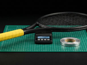 A tennis racquet being optimized with lead tape