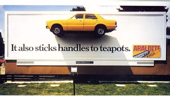Retro billboard advertisement for Araldite showing a car stuck to the billboard