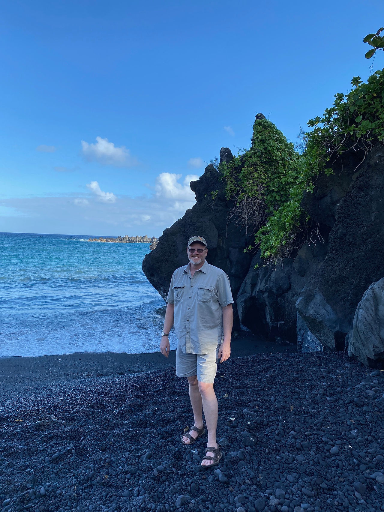 Man on black sand beach maui hawaii. Personal Escape Travel