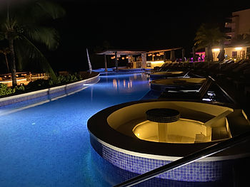 Night view of a resort pool with integrated hot tubs in St. Lucia.