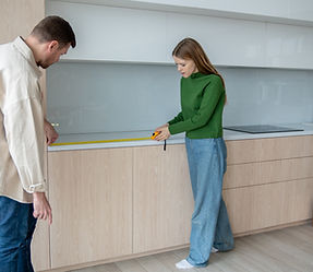 Couple measuring space for custom kitchen cabinets