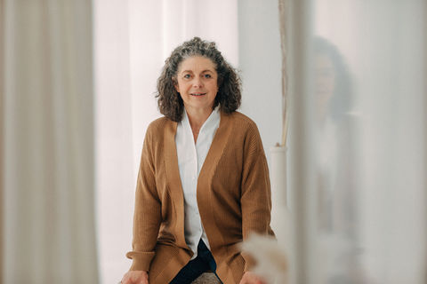 Coach sitzt entspannt im Studio bei einem Business-Fotoshooting.