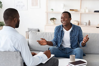 Successful Therapy. Cheerful black man talking to psychologist on meeting at his office, s