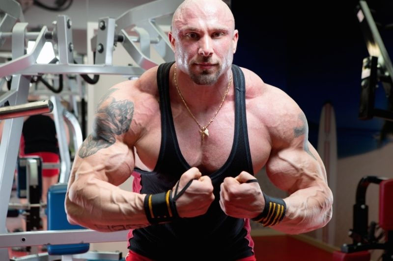 A bodybuilder tensing his upper body to show off his huge muscles.