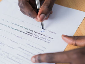 A person signing their Will.