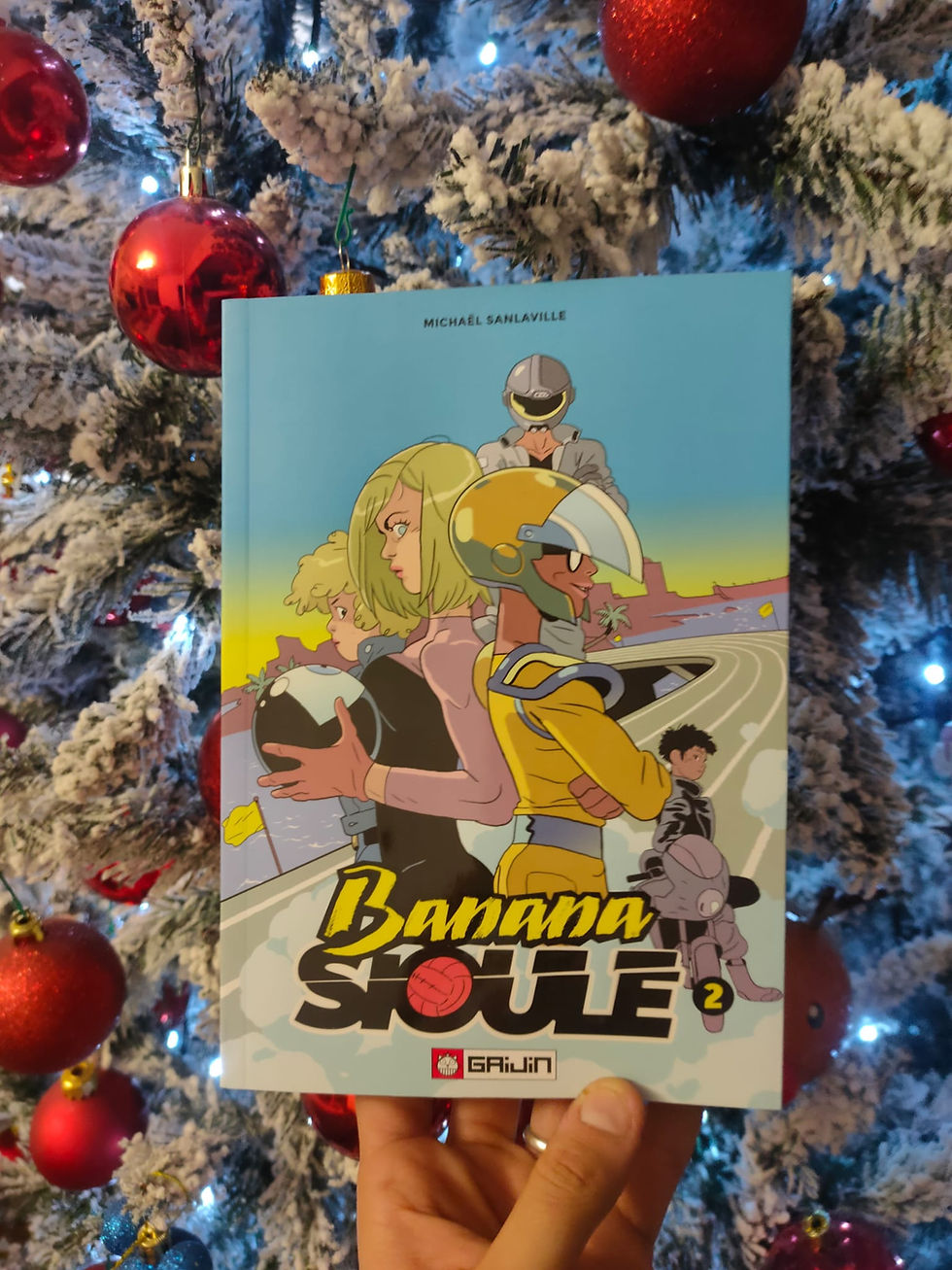 Fumetto Banana Souffle 3 in mano, su sfondo albero di Natale.
