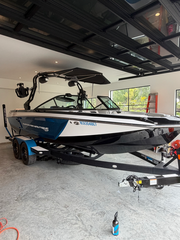 White and black wake boat after exterior detail and paint correction