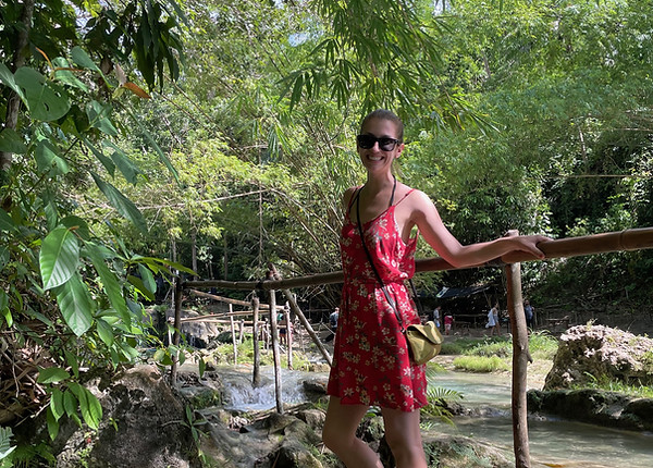 a woman leaning on a railing in the jungle in siquijor, the philippines