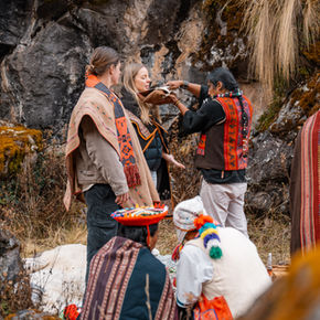 Small group receiving Andean priest blessing during intimate pago a la tierra wedding ceremony in the mountains.