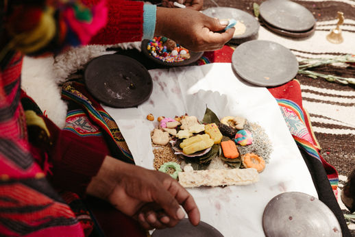 Hands gathered in a Haywarikuy ritual offering during an Andean ceremony in Peru
