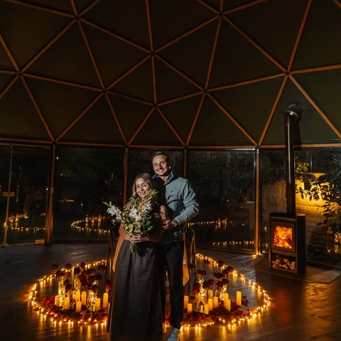 Engaged couple holding flowers inside a candlelit dome in Ollantaytambo Sacred Valley Peru