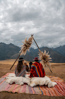 Traditional Andean wedding blessing in Maras with couple seated under pampas arch and shaman offering prayers