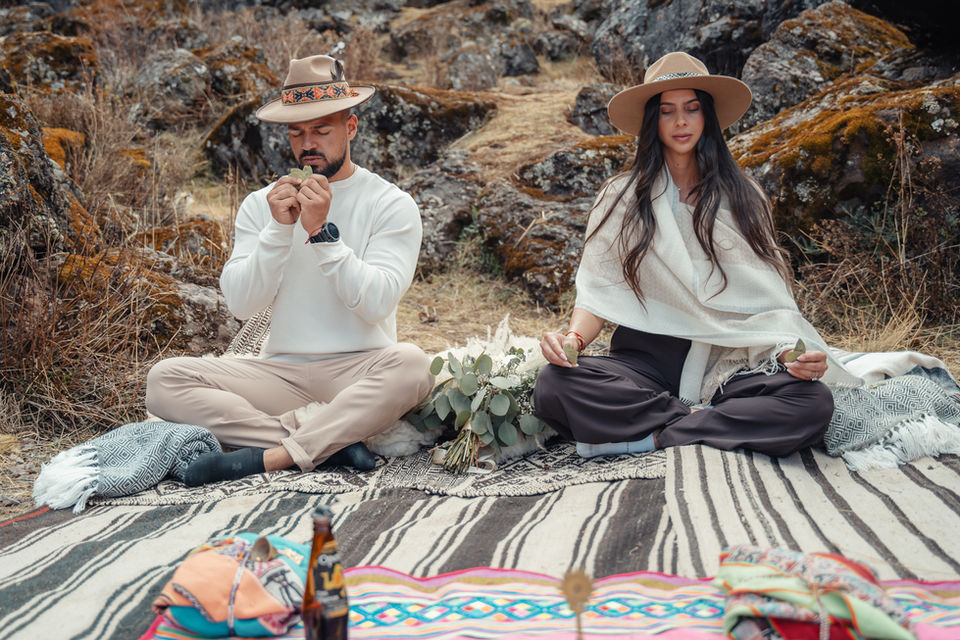 Couple seated in an intimate Andean wedding ceremony with a traditional priest in the Sacred Valley of Cusco