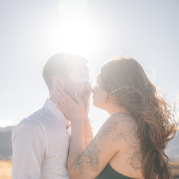 Romantic couple kissing at sunset during mountain proposal in the Sacred Valley of the Incas, Peru.