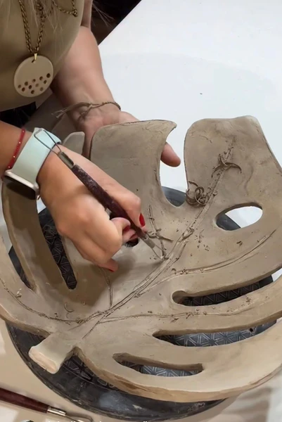 Taller de Ceràmica gres en Santiago, piezas hechas a mano sobre mesa de trabajo y un grupo de personas, un ambiente cálido y creativo de La Belleza de Crear