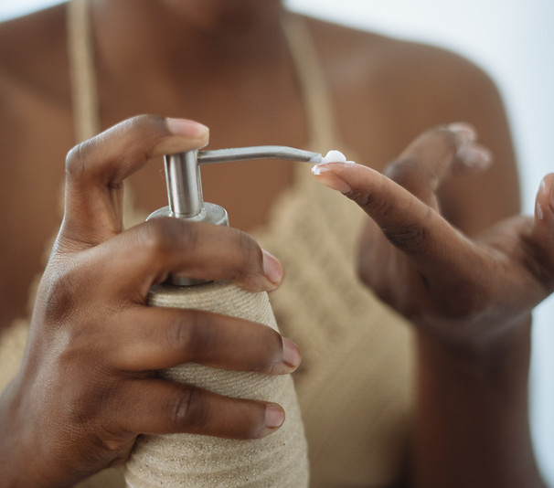 crop-woman-with-pump-bottle-of-cream-in-
