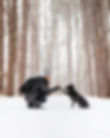 A woman and her dog high five in a snowstorm.