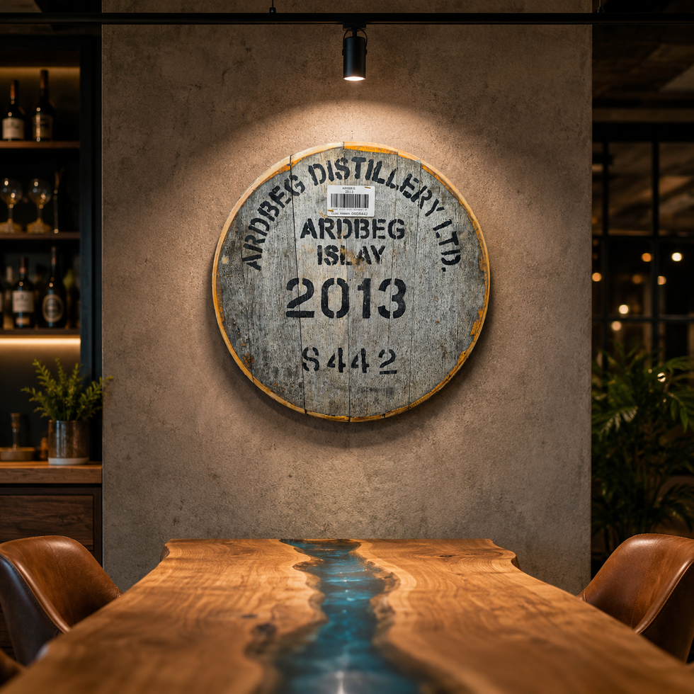 Round Ardbeg 2013 whisky cask head wall decor under a spotlight above a live edge wooden table in a dimly lit bar