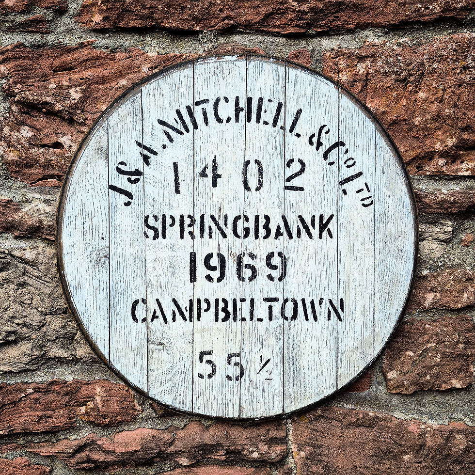 Springbank 1969 whisky cask head wall art with black stencilled lettering, mounted on a rustic stone wall.