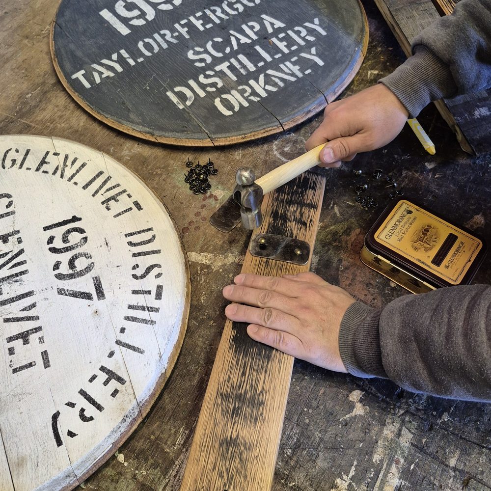 Marcin’s hands working on reclaimed whisky cask oak at the workshop bench