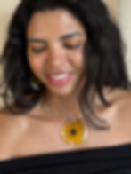Beautiful smiling brunette woman with loose hair wearing a handmade resin choker featuring a medium daisy, showcasing botanical jewellery.