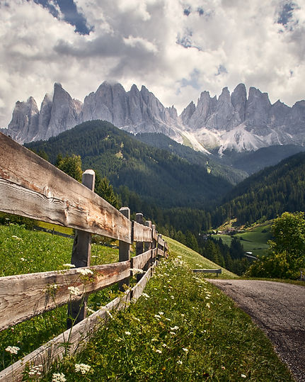 vertical-shot-wooden-fence-with-high-rocky-cliffs-funes-valley-st-italy.jpg