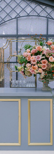 Blush rose floral arrangement on custom bar at Bridgerton-themed garden wedding venue