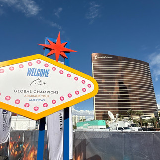 Vegas-style welcome sign for Global Champions Arabians Tour with Encore Hotel in background.
