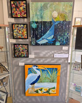 Art display featuring a whale painting and a heron painting.