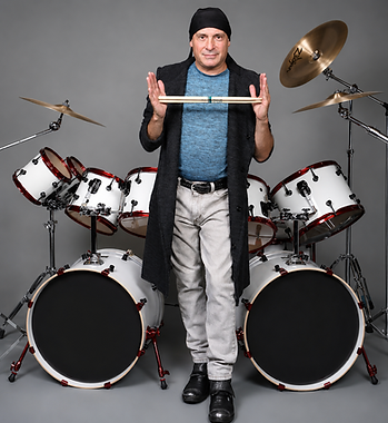 Drummer holding sticks in front of a white drum kit