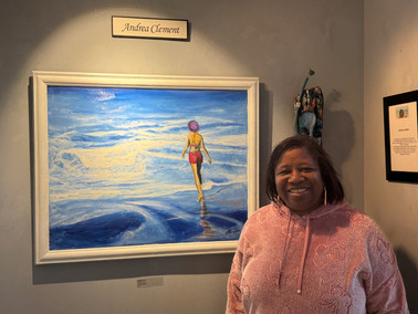 Andrea Clement standing next to her painting of a person walking on water