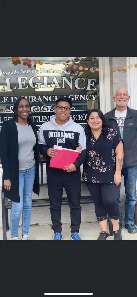 Four people smiling in front of ALLEGIANCE INSURANCE AGENCY OUR TEAM.