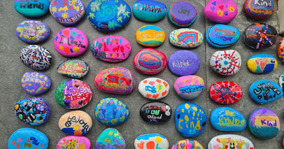 Collection of colorful painted kindness rocks with messages.