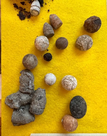 Various small, earthy brown and grey archaeological finds on yellow.