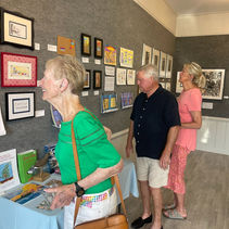 People viewing artwork at an indoor gallery exhibit.