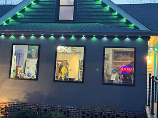 Small business at night with green lights and an OPEN sign